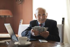 Retirement-age man holding money in NJ representing RetireReady NJ program