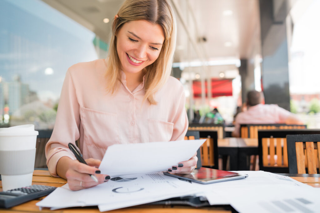 Small business owner reviewing payroll reports while discussing provider options with a colleague